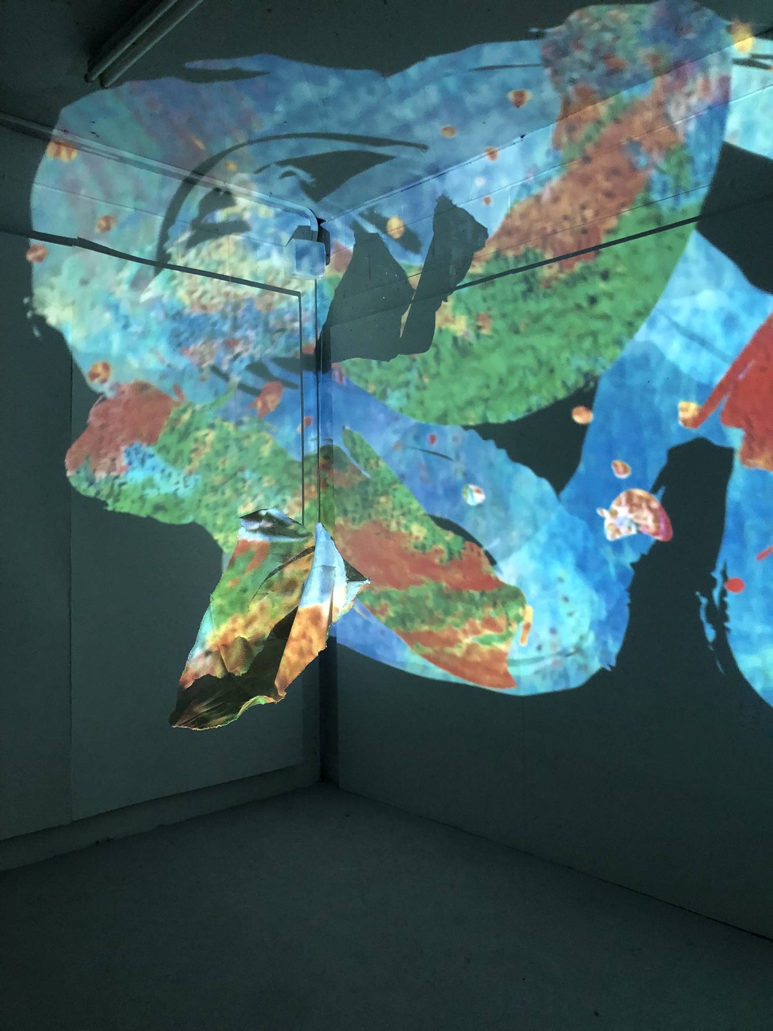 An image of an array of colourful digitized brushstrokes which "paint" the surface of a fabric sculpture which hangs in the centre of the space