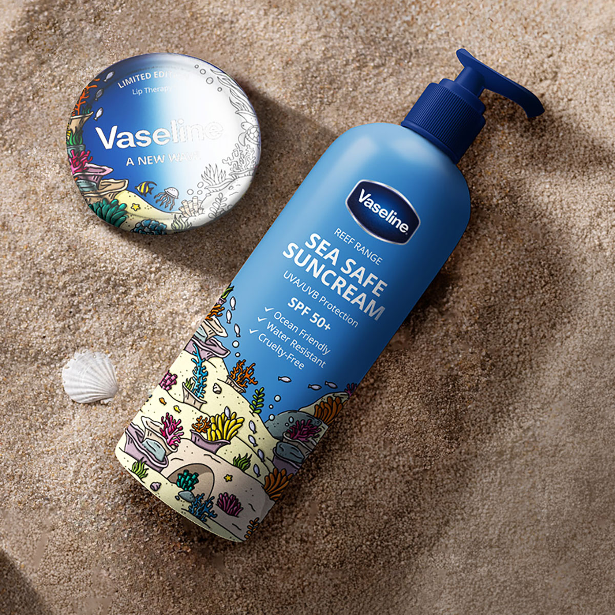 Vaseline Reef Range sunscreen and lip therapy products on sand with coral reef-themed packaging, highlighting ocean-safe, cruelty-free SPF 50+ sun protection.