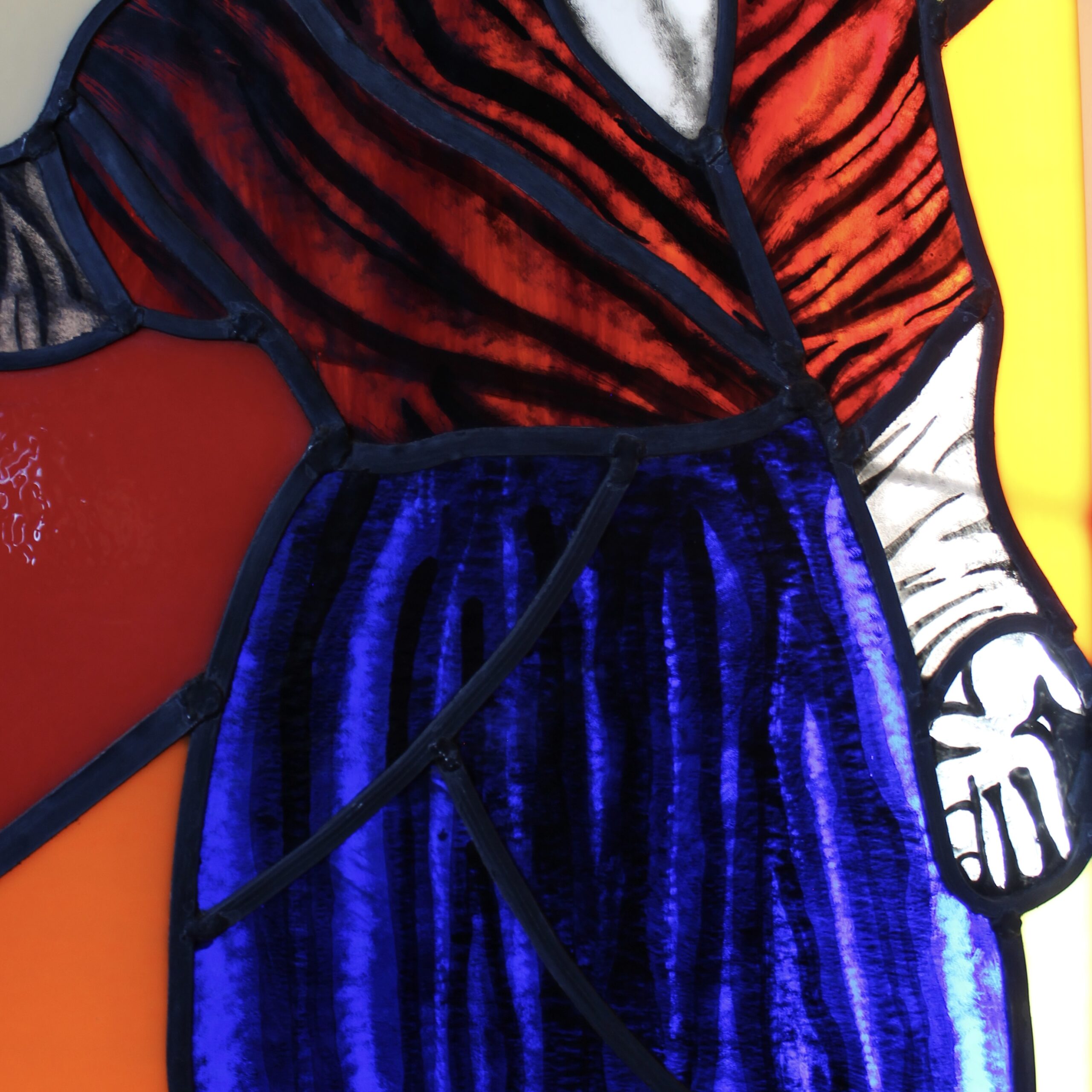 Photograph of clothing details on the stained glass panel.