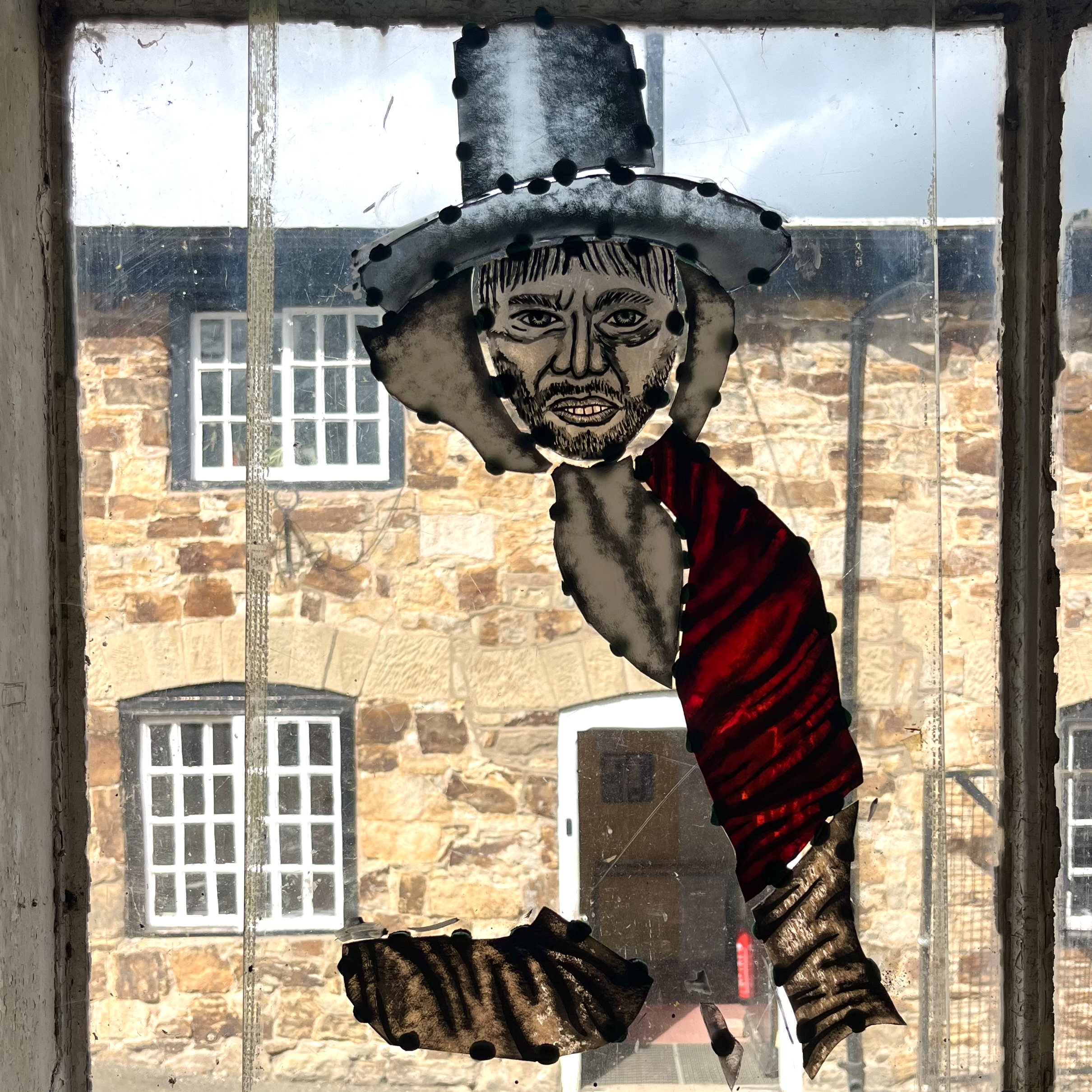 Photo showing the painted glass propped up against a window.