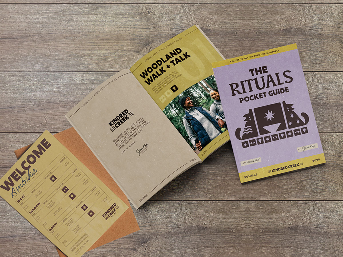 A schedule of activities taking place at the retreat on a table next to an open activities guide. There is also a closed activities guide next it it with a purple front cover, featuring rustic illustrations of wolves.